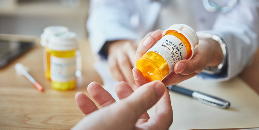 Doctor handing medication to a patient