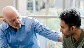 older man supporting younger man